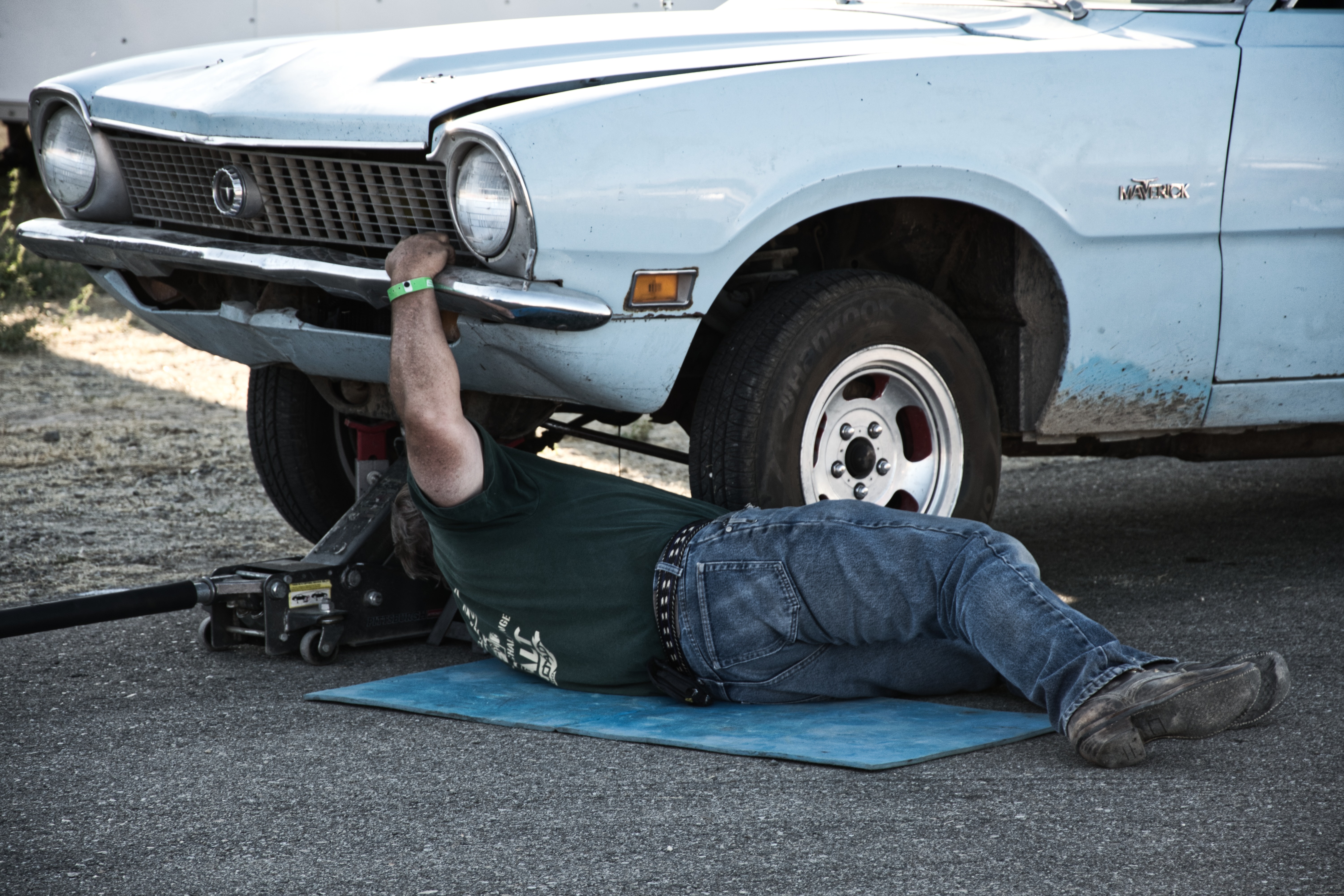 Man working under car lifted by car jack